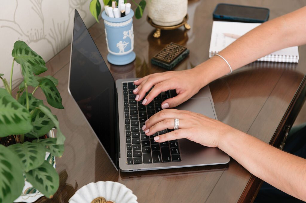 Hands typing on laptop